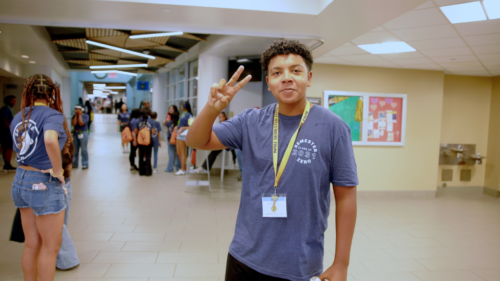 scholar holding peace sign